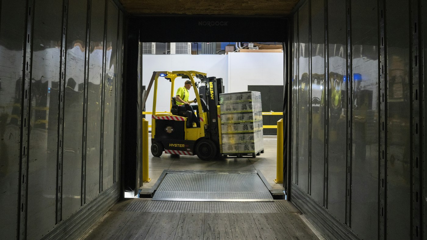 トラックの荷台の奥から見た、荷物を運び込むフォークリフト